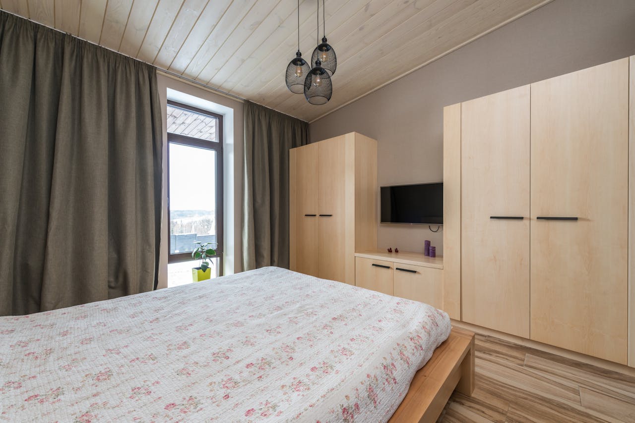 about-us Inviting bedroom showcasing modern interior design with warm wooden elements and natural light.